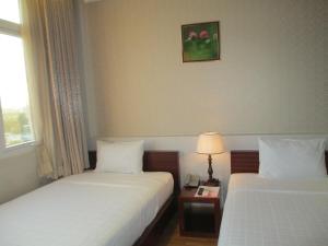 Postel nebo postele na pokoji v ubytování Anh Dao Mekong Hotel