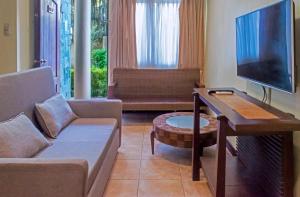 a living room with a couch and a flat screen tv at Sheridan Villas Boracay in Boracay