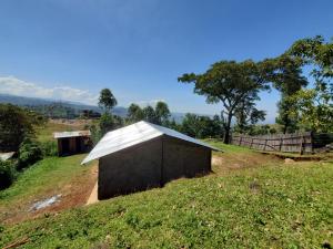 a small building with a roof on a field at Sunrise homestay Sipi in Kapchorwa