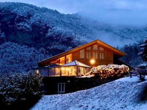 Una casa en una colina en la nieve por la noche en Ferienwohnung Aareschlucht - Erholung ab 2 Nächten, en Rohrmatten