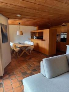 ein Wohnzimmer mit einem Tisch und einer Küche in der Unterkunft Ferienwohnung Aareschlucht - Erholung ab 2 Nächten in Rohrmatten