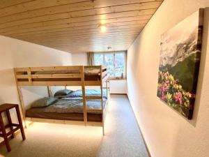 Schlafzimmer mit Etagenbett und Wandgemälde in der Unterkunft Ferienwohnung Aareschlucht - Erholung ab 2 Nächten in Rohrmatten