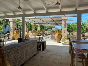 een patio met tafels, stoelen en vazen bij Tenuta Palmira agriturismo in Salve