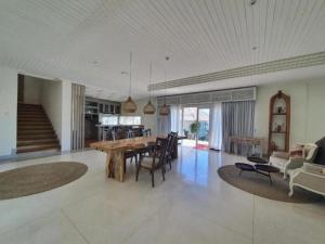 a dining room and living room with a table and chairs at Adiwana Jelita Sejuba Natuna in Ranai