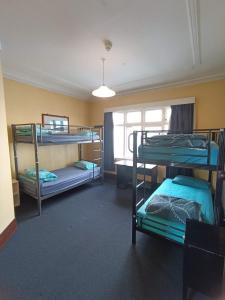 um quarto com 3 beliches e uma janela em Rotorua Central Backpackers em Rotorua