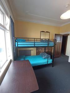 two bunk beds in a room with a table at Rotorua Central Backpackers in Rotorua