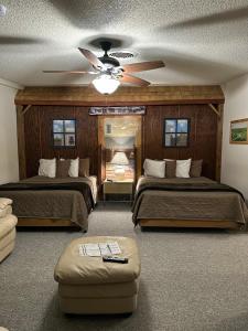 1 dormitorio con 2 camas y ventilador de techo en Country Cabins Hotel, en Chariton