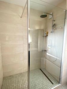La salle de bains est pourvue d'une douche avec une porte en verre. dans l'établissement Appartement spacieux à Pontaillac, proche plage, à Royan