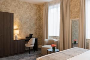 a hotel room with a bed and a desk and a chair at Dukes' Academie Brugge - by Dukes' Hotel Collection in Bruges