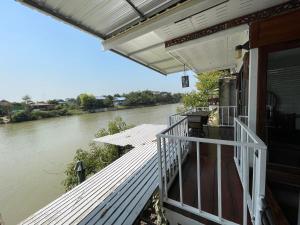 a house with a deck next to a river at Baan Keang Chon Ayutthaya บ้านเคียงชล อยุธยา in Phra Nakhon Si Ayutthaya