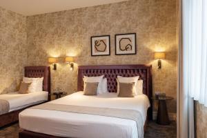 a hotel room with two beds and two lamps at Dukes' Academie Brugge - by Dukes' Hotel Collection in Bruges