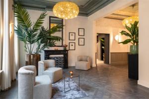 a living room with two chairs and a fireplace at Dukes' Academie Brugge - by Dukes' Hotel Collection in Bruges