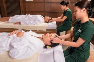 deux filles dans une salle de massage avec un patient dans l'établissement Oakwood Ha Long, à Hạ Long