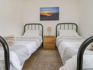 two beds sitting next to each other in a bedroom at An Garth in Penzance