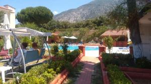 a couple sitting in a swing by a swimming pool at Boncuklu Otel in Fethiye