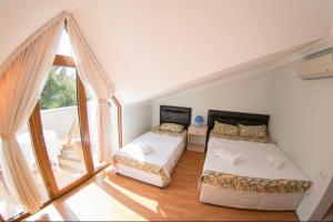 a bedroom with two beds and a large window at Boncuklu Otel in Fethiye