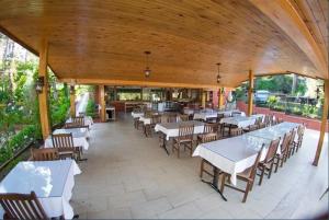 a restaurant with white tables and chairs and a large ceiling at Boncuklu Otel in Fethiye