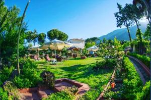 a garden with umbrellas and tables and chairs at Boncuklu Otel in Fethiye