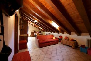 sala de estar con sofá rojo y mesa en Valley Vacanze, en Brusson