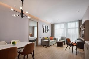 a living room with a couch and a dining room at Home2 Suites by Hilton Guiyang Airport in Guiyang