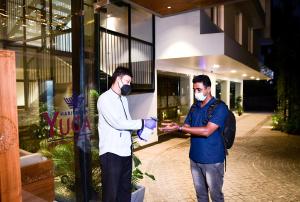 deux hommes portant un masque facial debout à l'extérieur d'un bâtiment dans l'établissement Harivaram Yuga, à Guruvāyūr