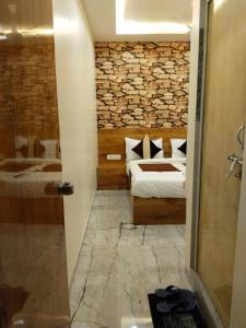 a bedroom with a bed and a stone wall at Hotel Skyland in Ahmedabad