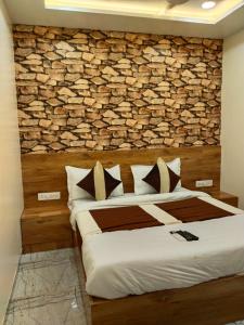 a bedroom with a bed with a brick wall at Hotel Skyland in Ahmedabad