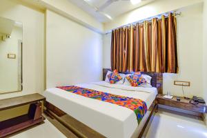 a bedroom with a large bed and a window at FabExpress Red Apple in Ahmedabad