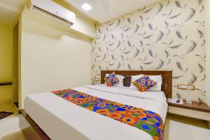um quarto com uma cama com uma parede estampada em FabExpress Red Apple em Ahmedabad