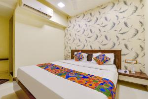 a bedroom with a bed with a patterned wall at FabExpress Red Apple in Ahmedabad