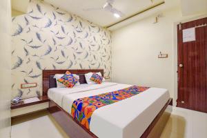 a bedroom with a bed with a patterned wall at FabExpress Red Apple in Ahmedabad
