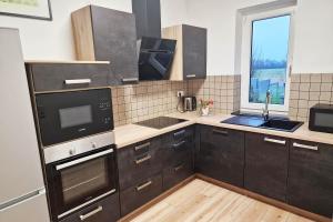 d'une cuisine avec des placards noirs, un évier et une fenêtre. dans l'établissement Work & Stay in Kranenburg near Kleve, à Kranenburg