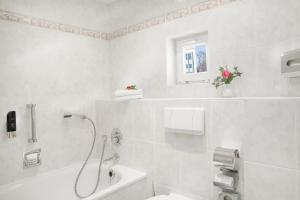 Un baño blanco con ducha y lavabo. en Gästehaus Kaiserhof Lübeck, en Lübeck
