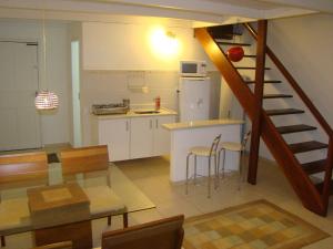 a kitchen and dining room with a staircase in a house at Apartamento Búzios in Búzios