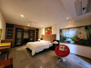 a bedroom with a bed and a large painting on the wall at Bougainvillea Terrace House in Kata Beach
