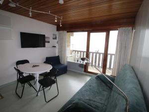 a living room with a couch and a table at Studio Cabine Rénové au Pied des Pistes avec Balcon - Auris en Oisans - FR-1-297-157 in Auris