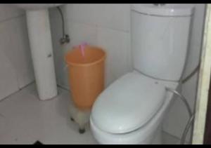 a bathroom with a toilet and a trash can at Hotel M. S. Palace By WB Inn in Agra