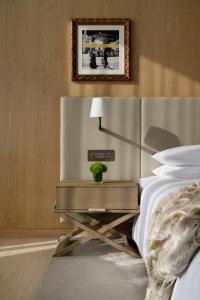 Un dormitorio con una cama y una mesa con una planta. en The Dubai EDITION, en Dubái