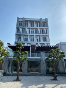 LÊ ĐOÀN HOTEL في راش غايا: مبنى ابيض كبير امامه اشجار
