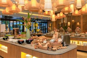 une femme debout derrière un comptoir dans un restaurant dans l'établissement Oakwood Ha Long, à Hạ Long