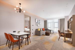 un soggiorno con tavolo, sedie e divano di Home2 Suites By Hilton Shenzhen Dalang a Shenzhen