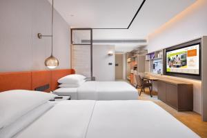 Habitación de hotel con 2 camas y TV de pantalla plana. en Home2 Suites By Hilton Shenzhen Dalang, en Shenzhen