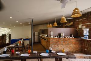 a restaurant with wooden tables and a brick wall at Avontade Suites in Anjuna