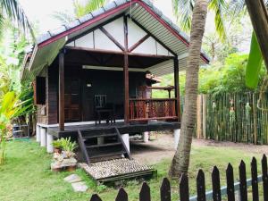 uma pequena cabana com um alpendre e uma cerca em First Villa Beach Resort em Ban Tai