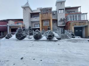 un edificio con nieve en el suelo delante de él en TURAN SEMEY GRAND HOTEL, en Semey