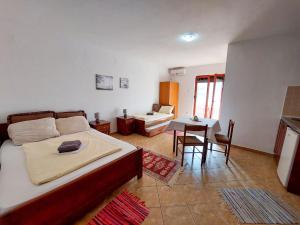 a bedroom with a bed and a table and chairs at Apartments Normannia in Dobra Voda