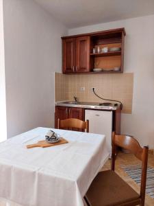 a kitchen with a table with a white table cloth on it at Apartments Normannia in Dobra Voda