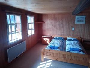 ein Schlafzimmer mit einem Bett in einem Zimmer mit Fenstern in der Unterkunft Antikes Ferienhaus in Trub