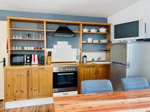 a kitchen with wooden cabinets and a refrigerator at Landhaus Angerhof in Bad Hofgastein