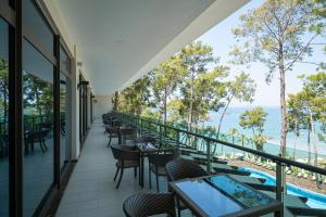 Un balcón con mesas y sillas y vistas al océano. en Wome Prime Hotel - Halal All Inclusive, en Alanya
